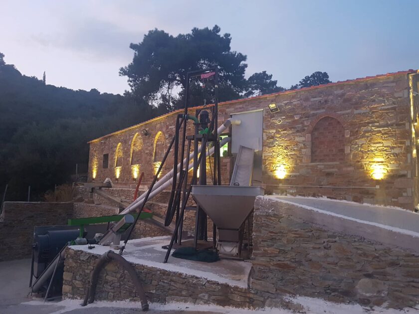 Photo of our traditional style stone wall olive mill building illuminated.